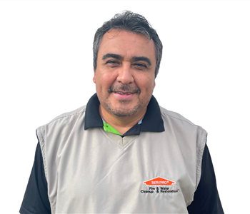Man with dark hair wearing a SERVPRO shirt against white backdrop