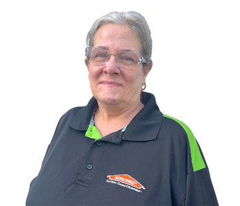 Professional woman wearing SERVPRO polo shirt against a white backdrop.